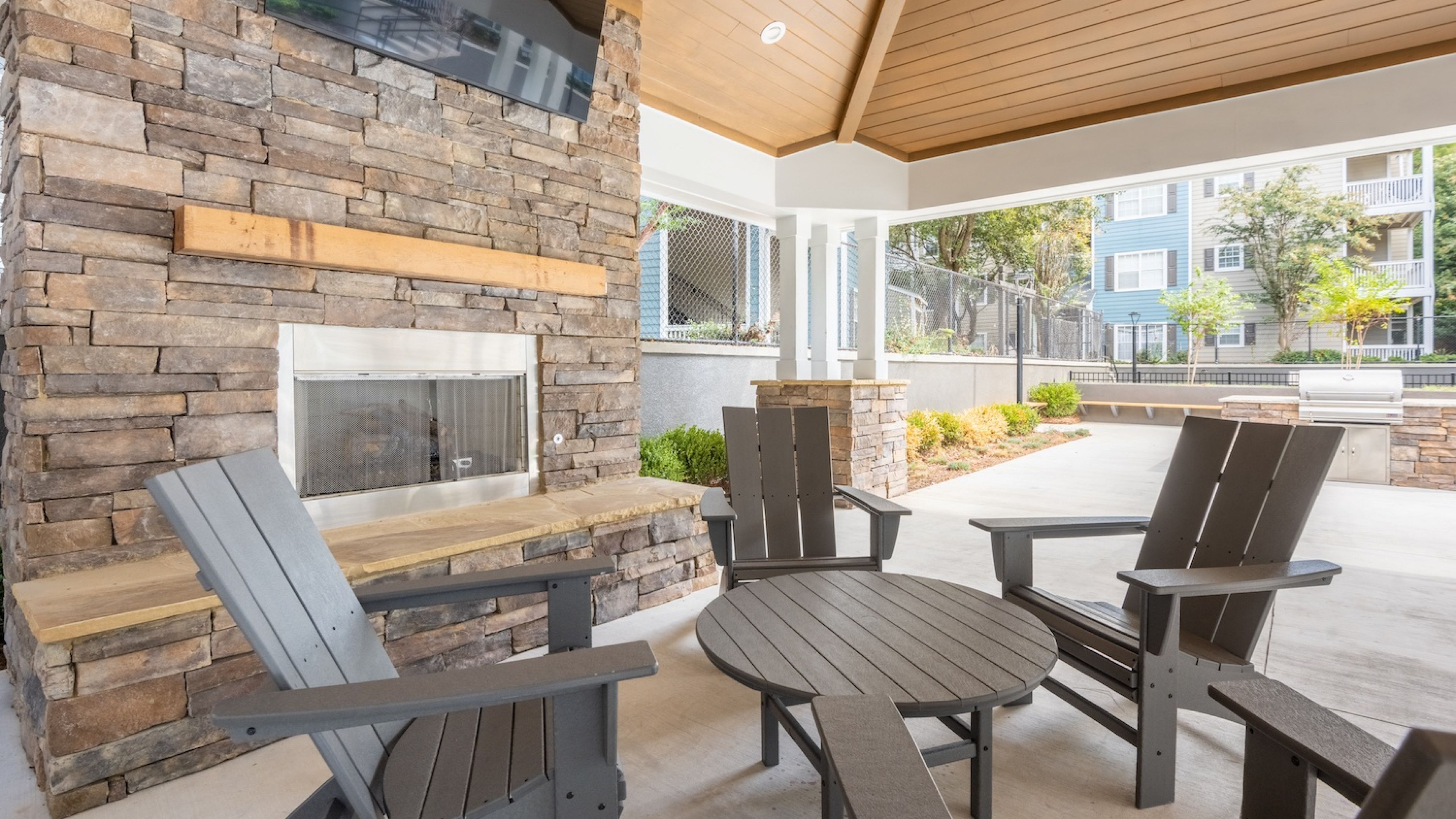 Hawthorne North Druid Hills amenity lounge area with fireplace, tv, and outdoor grilling area