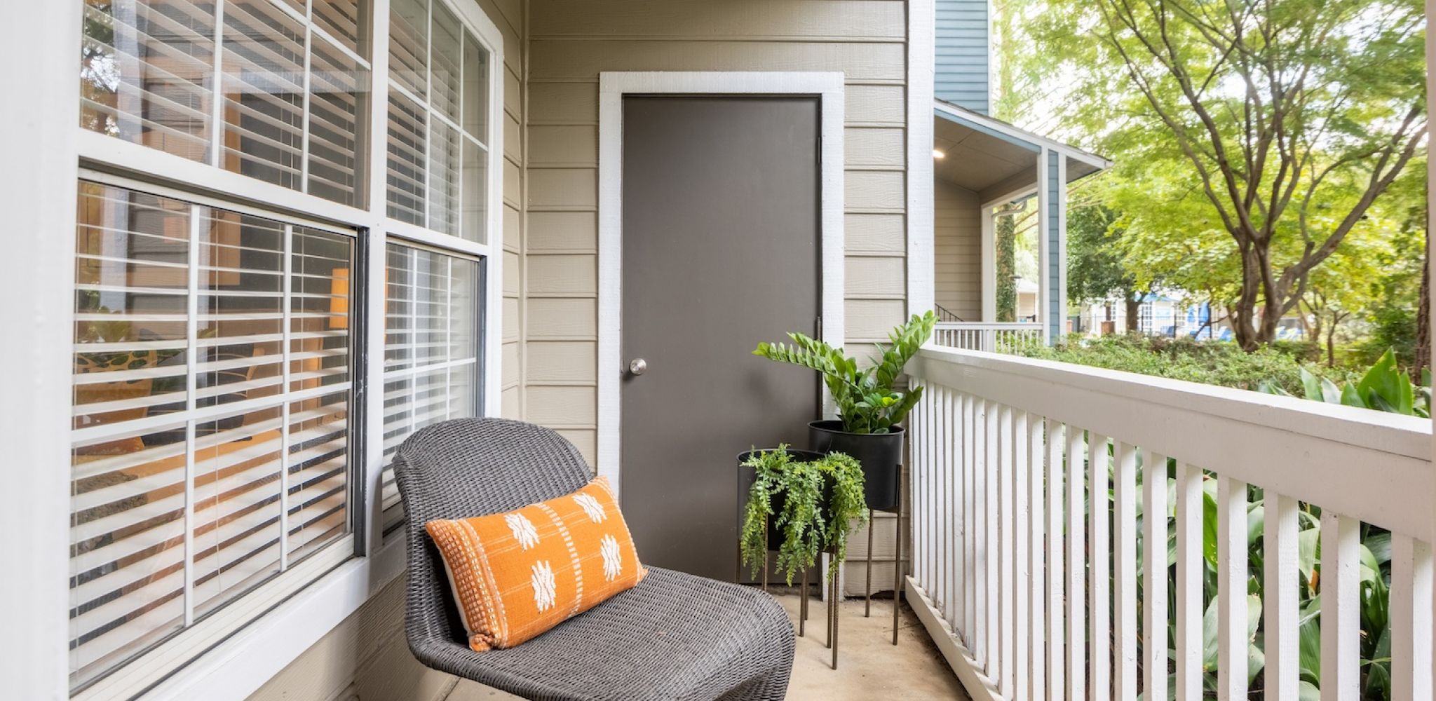 Hawthorne North Druid Hills apartment patio with garden view, furnished with outdoor chair and potted plants