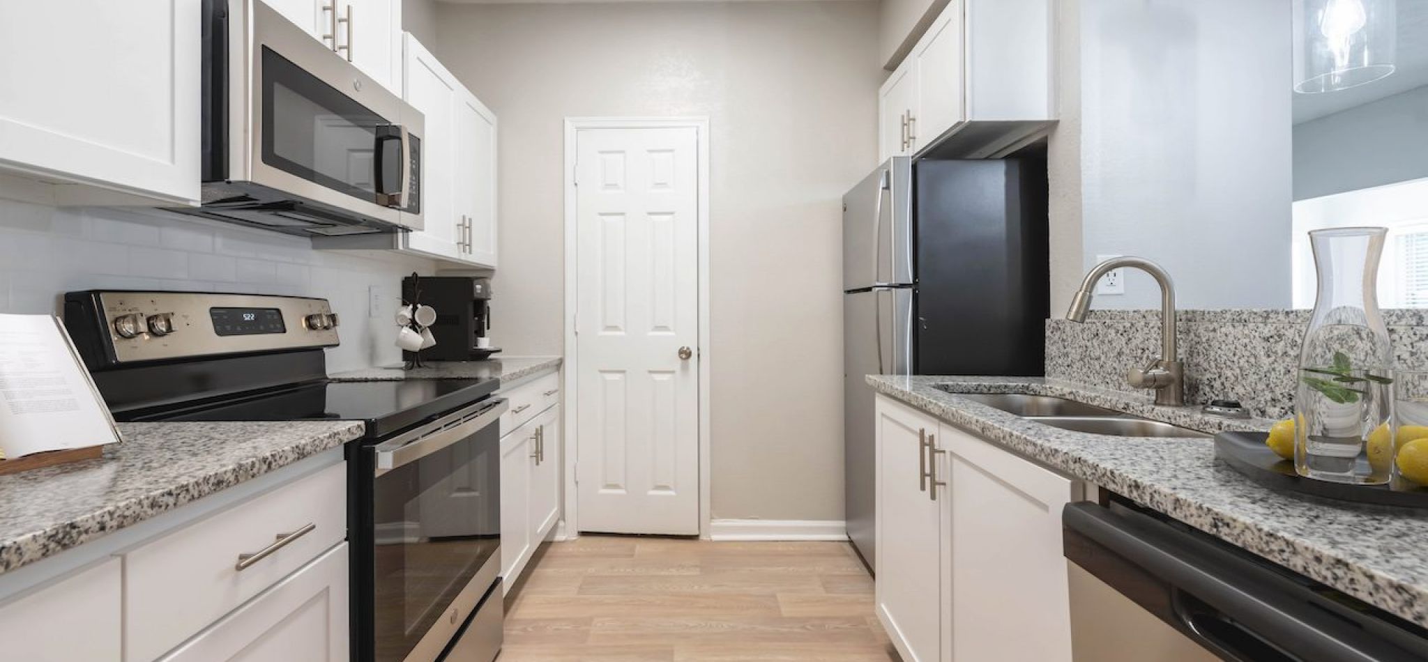 Hawthorne North Druid Hills apartment kitchen interior with granite countertops, stainless steel appliances, and custom cabinetry