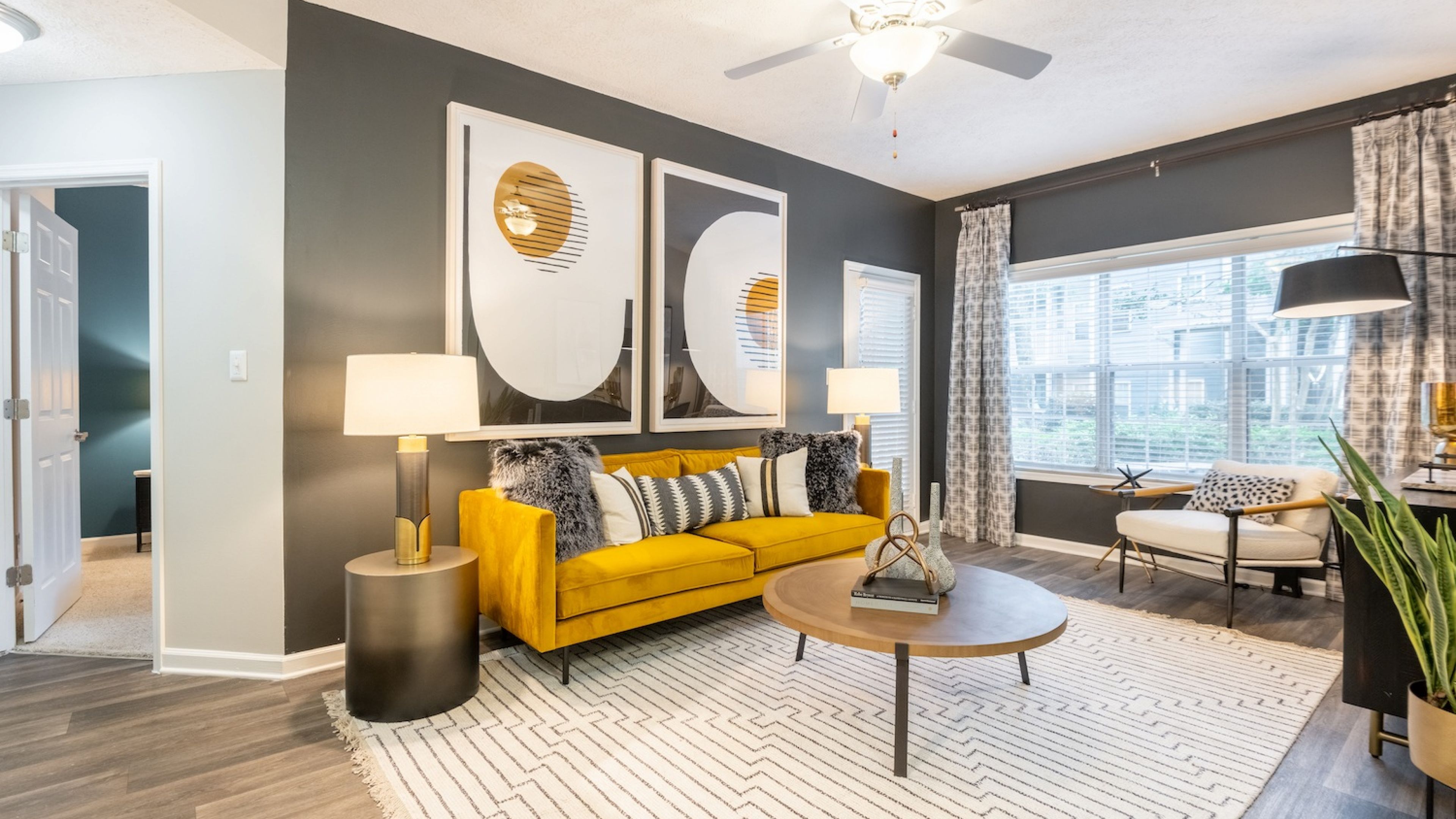 Hawthorne North Druid Hills apartment living room with large windows, patio door, furnished with a couch, coffee table, and chair